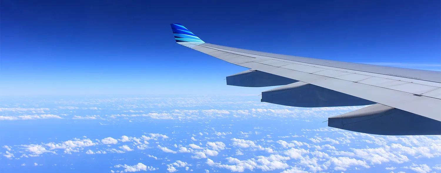 An aeroplane wing with blue sky in the background