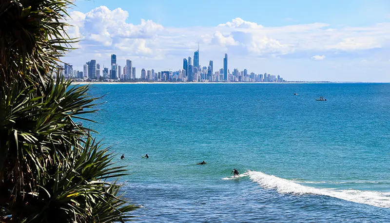 Surfing in Australia on the Gold Coast Surfers on blue sea with cityscape backdrop