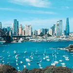 Cityscape with skyscrapers and harbour with boats and bridge