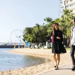 Two people walking along waterfront path