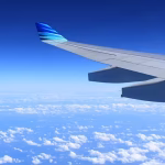 An aeroplane wing with blue sky in the background