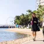 Two people walking alongside a body of water