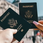 Two passports being held in the air
