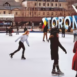 People ice skating next to a large sign