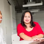 Two women looking at a laptop screen together