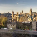 Image of modern and old buildings with soft yellow light shining on them