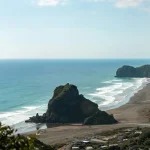 Beach with white waves around large rocks