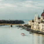 Big red-roofed buildings next to a river