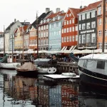 Colourful houses next to a canal with lots of boats on it