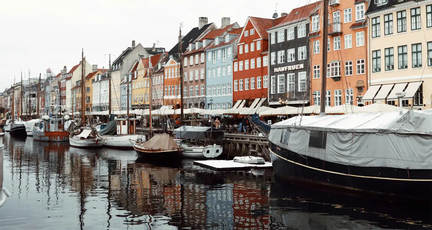 Colourful houses next to a canal with lots of boats on it