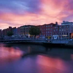 Buildings next to a river at sunset