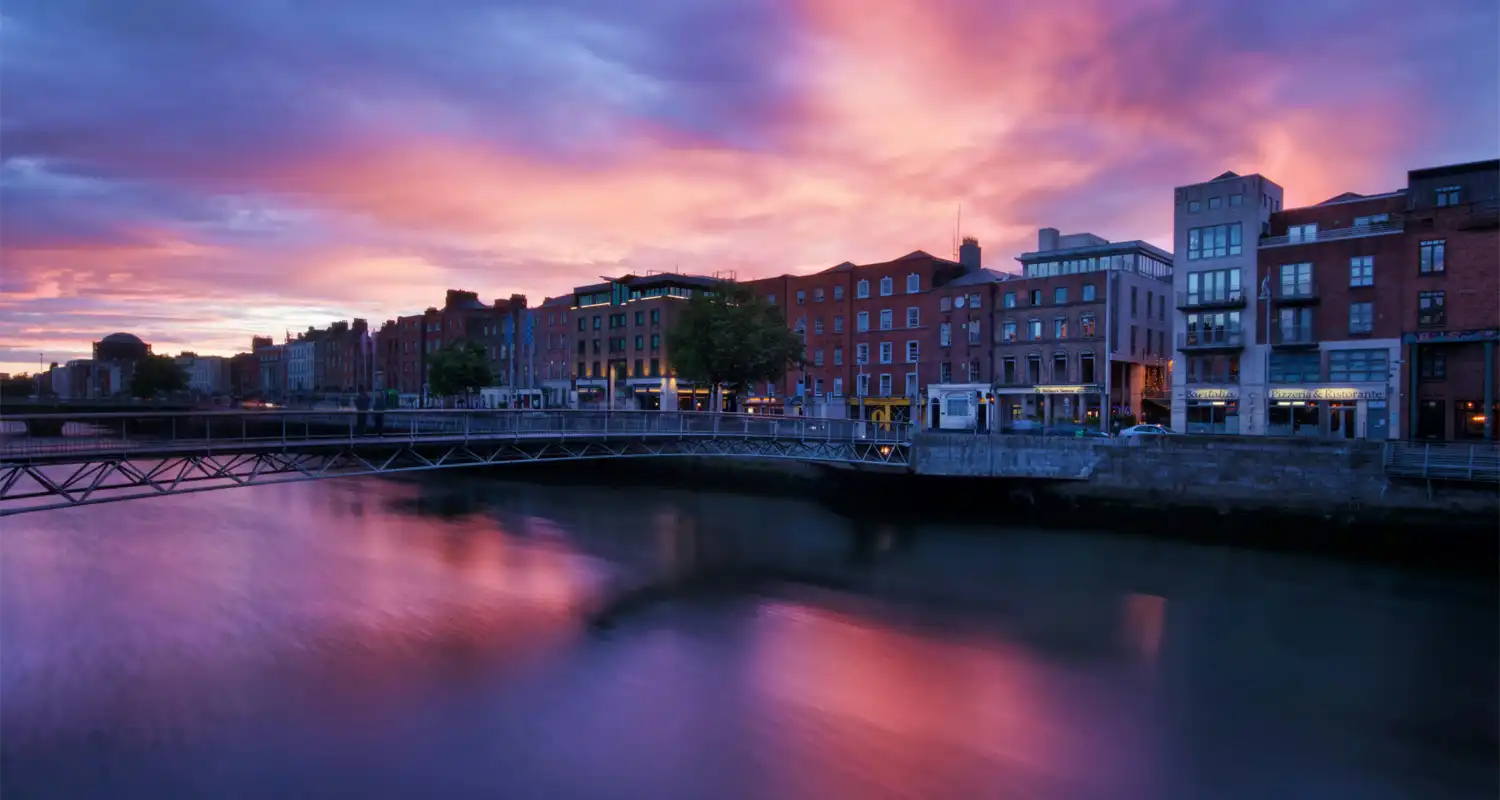 Buildings next to a river at sunset