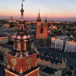 City skyline with red brick buildings and a sunset in the background