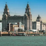 Image of a river with some large buildings behind it