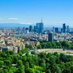 City skyline with mountains in the background and trees in the foreground
