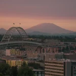 Image of a mountain behind a bridge and cityscape