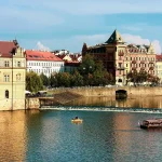 Building next to a river with the sun shining on it