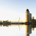 Image of high rise buildings reflecting on a body of water