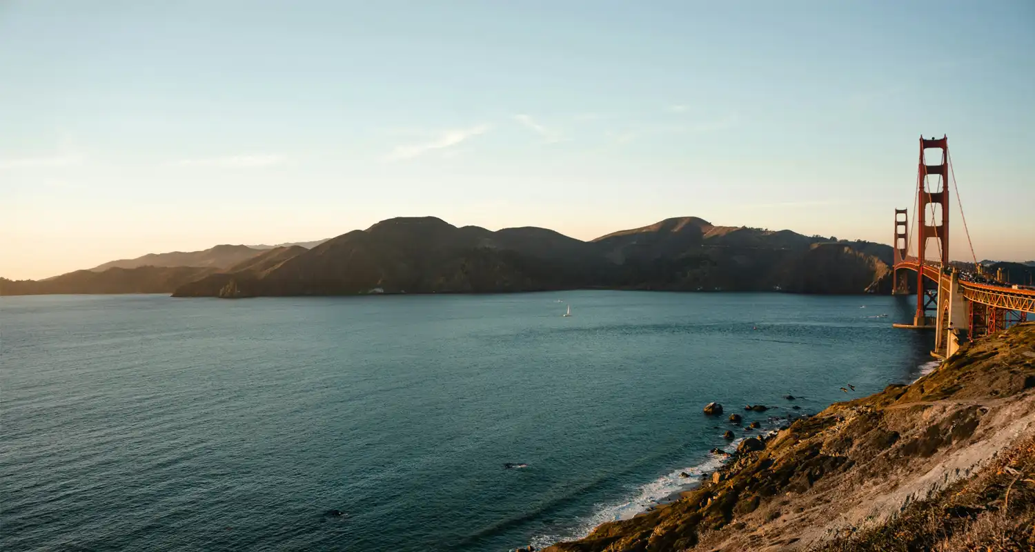 Image of a long red bridge going across a body of water