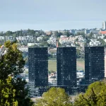 City skyline with modern buildings and trees in the foreground