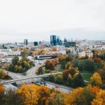 City skyline with green spaces and autumnal trees in the foreground