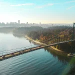 Image of a body of water with a bridge crossing it and a city skyline in the far distance