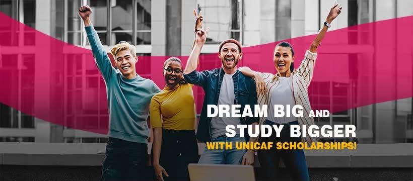 Four students with their hands in the air smiling at the camera