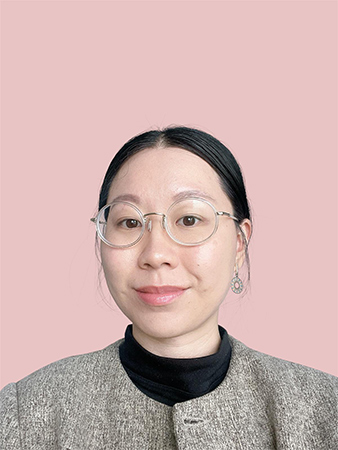 Image of a student wearing a grey jacket and glasses, against a light pink background