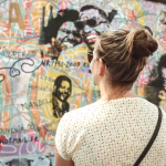 Lady viewing a wall covered with colourful graffiti