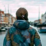 Woman looking at river between colourful buildings