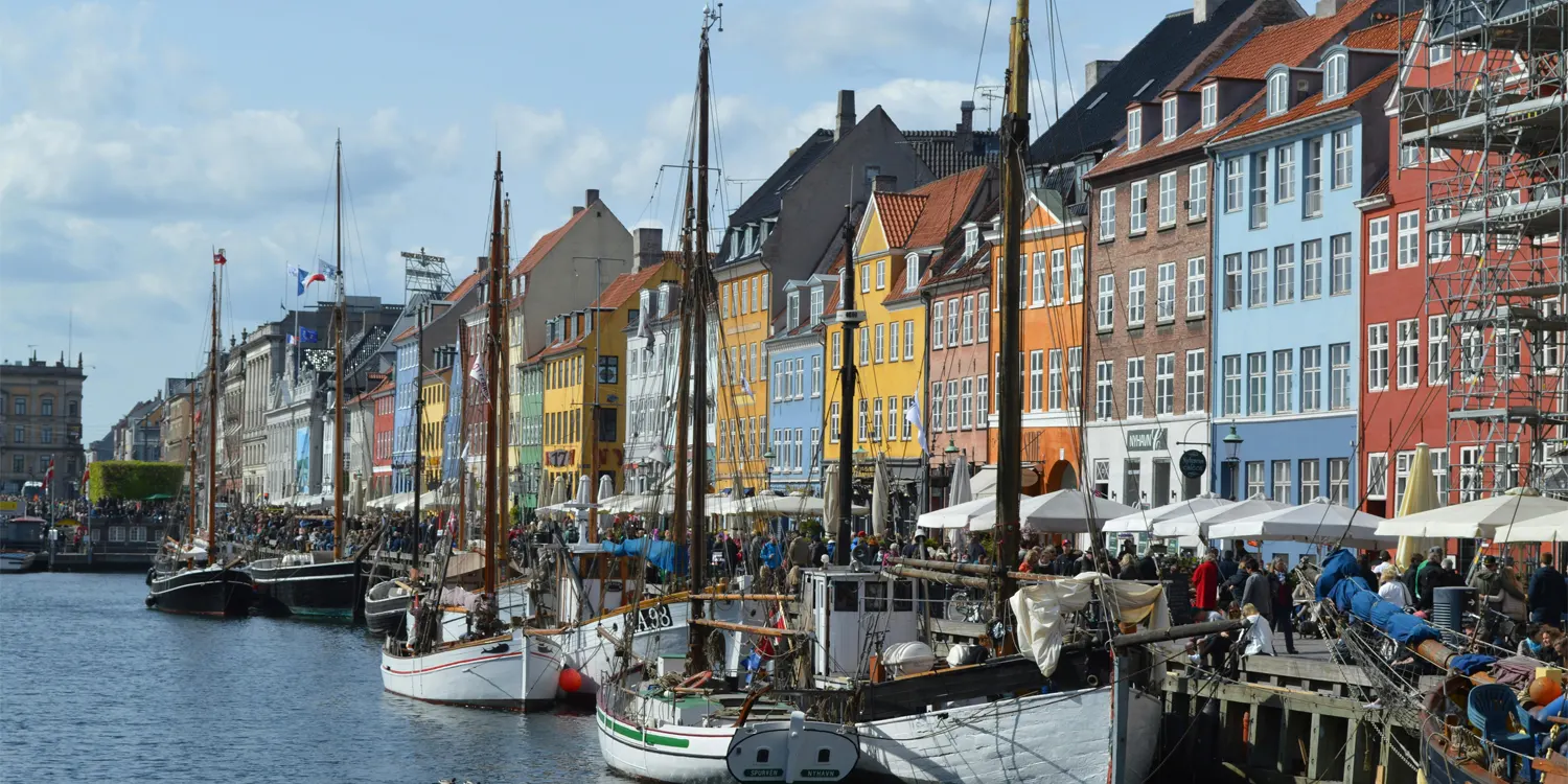 Colourful houses next to a canal with boats on it
