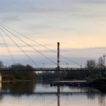 A bridge over water and a tall building next to it