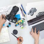 A laptop, a camera and some sketches