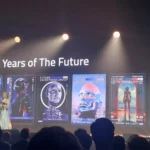 A person on stage with a presentation behind them