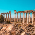 A ruined building and some columns still standing, all made of sandstone