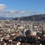 A city skyline with a mountain in the background