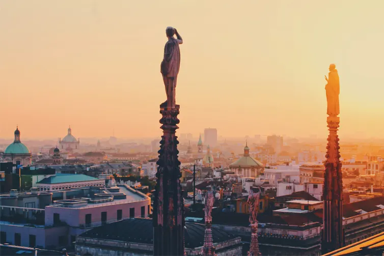 City skyline at sunset, with statues in foreground