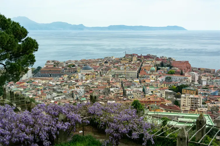 View of a city that is by the sea, with buildings closely packed together.