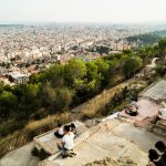 People on a hill overlooking a large city