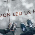 View of two pairs of shoes next to motivational slogan
