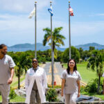 Students walking outside with a tropical scene in the background.
