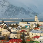 Colourful city buildings with snow covered mountains in the background