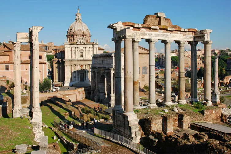 Ancient roman architecture ruins with people looking at them.