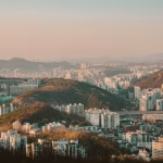 A sprawling city of white hi-rise buildings amongst hills