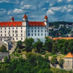A white and red castle surrounded by trees