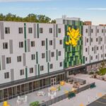 Image of a long white building with green and yellow accents on it