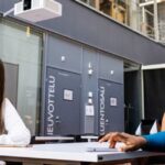 Image of 3 students sat at a table looking away from the camera