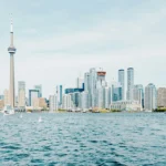 City skyline with tall buildings in the background and water in the foreground