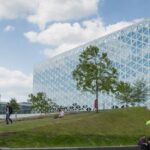 Image of a large glass building on top of a grassy hill